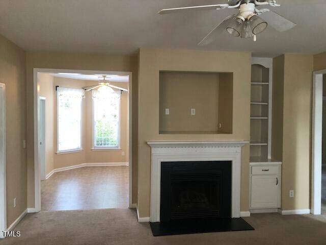125 Hardaway Point Clayton, NC 27527 - Photo 2 of 17 a living room with a fireplace and a ceiling fan