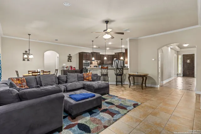 a living room with furniture and a dining table with kitchen view