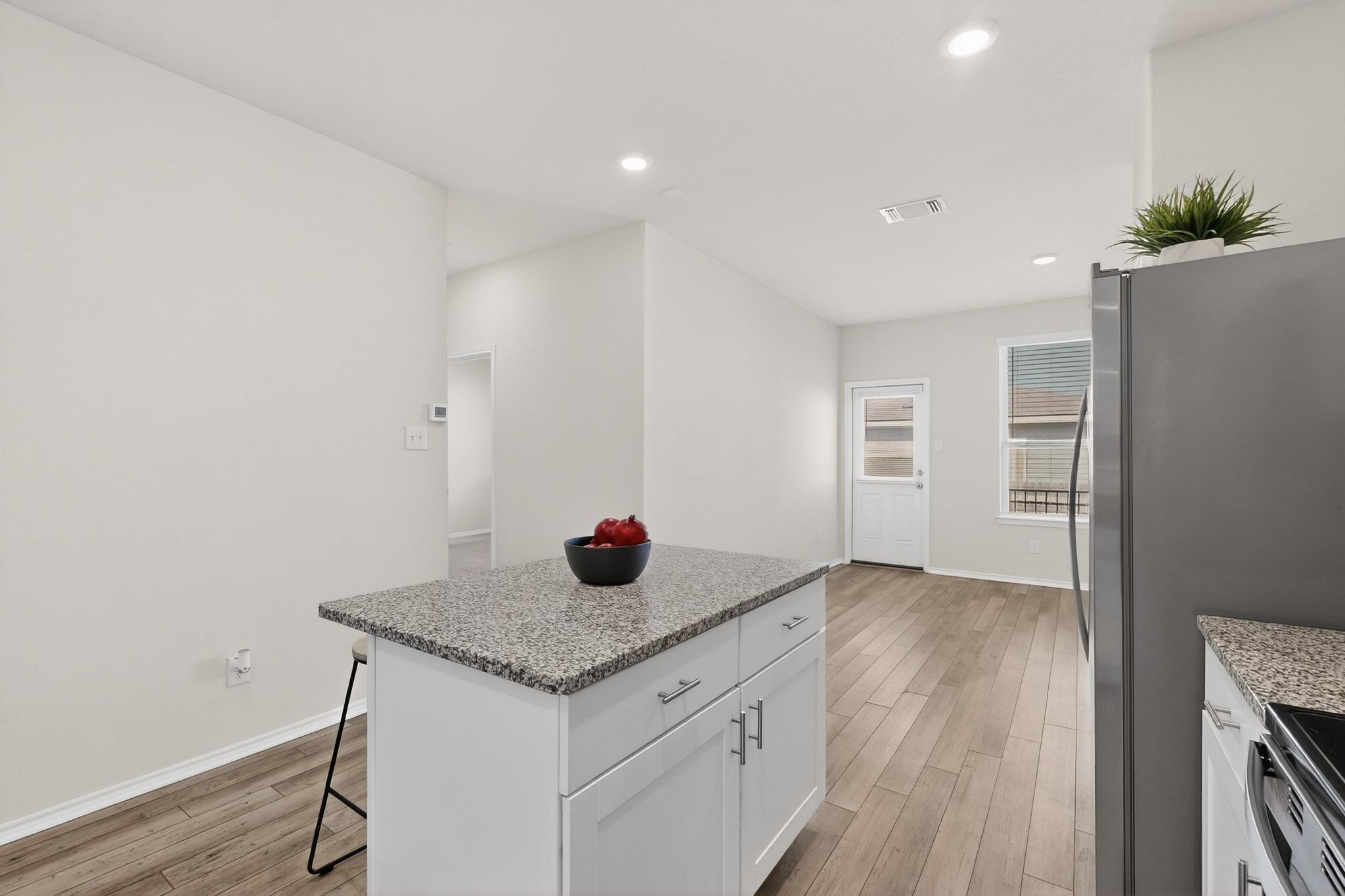 429 Stone Water Lane Jarrell, TX 76537 - Photo 11 of 37 a kitchen with stainless steel appliances granite countertop a sink and a refrigerator