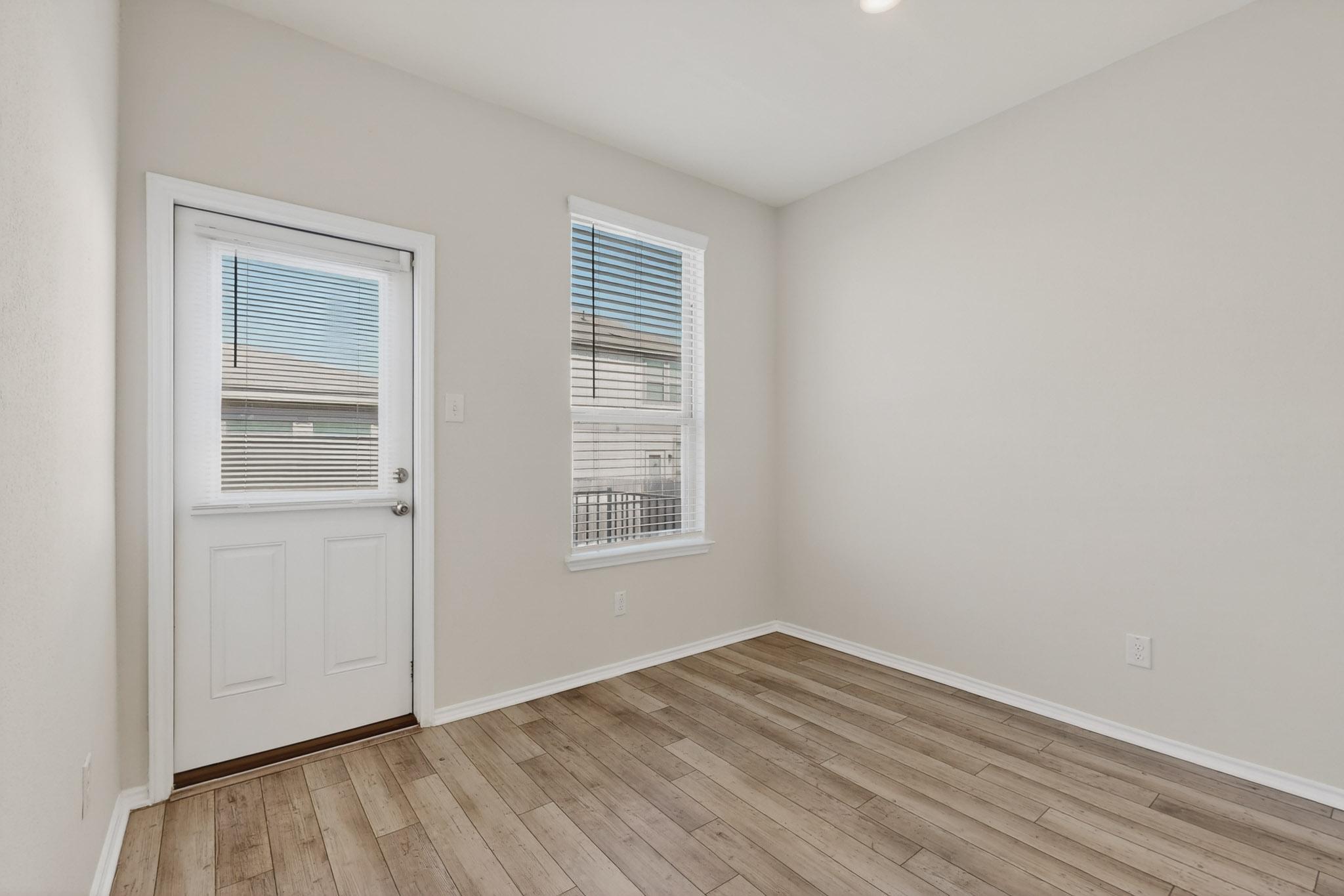 429 Stone Water Lane Jarrell, TX 76537 - Photo 12 of 37 an empty room with wooden floor and windows