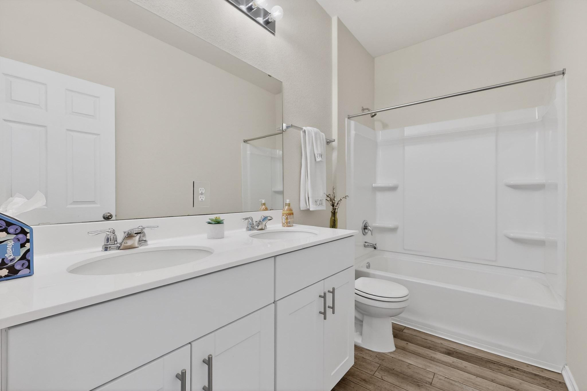 429 Stone Water Lane Jarrell, TX 76537 - Photo 23 of 37 a bathroom with a double vanity sink toilet mirror and shower