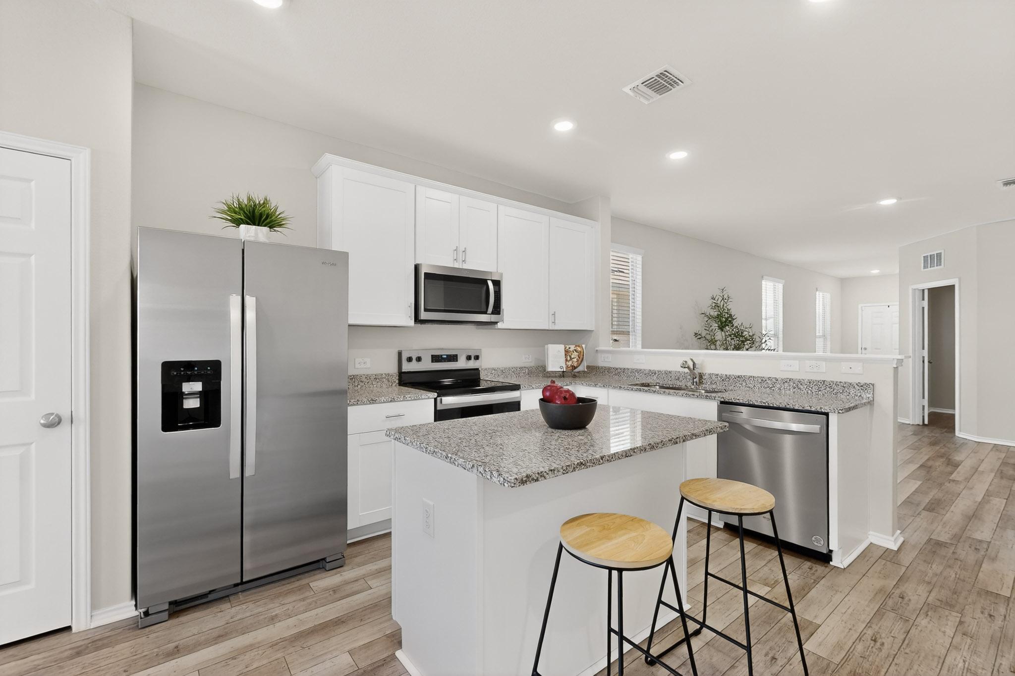 429 Stone Water Lane Jarrell, TX 76537 - Photo 8 of 37 a kitchen with kitchen island granite countertop a sink cabinets and refrigerator
