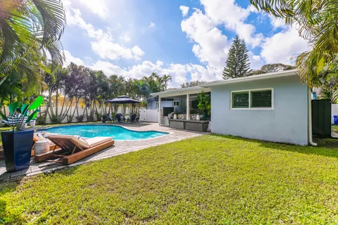 a view of a swimming pool with a lounge chair and small yard