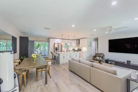 a living room with furniture kitchen view and a large window