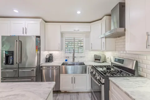 a kitchen with a stove a sink and a refrigerator
