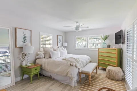 a bedroom with a bed wooden floor and window