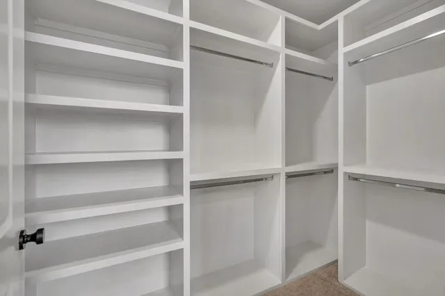 a view of an empty room with window and cabinet