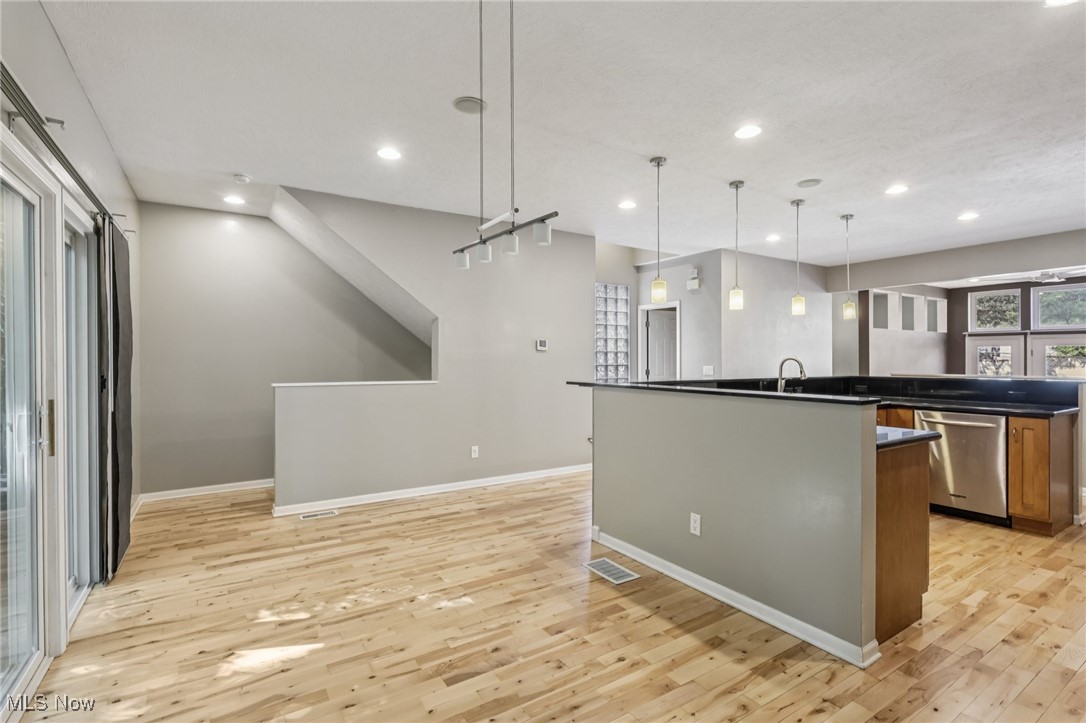 1951 Columbus Road Cleveland, OH 44113 - Photo 14 of 46 Kitchen featuring recessed lighting, dishwasher, wood-style flooring, decorative light fixtures, and an island with sink