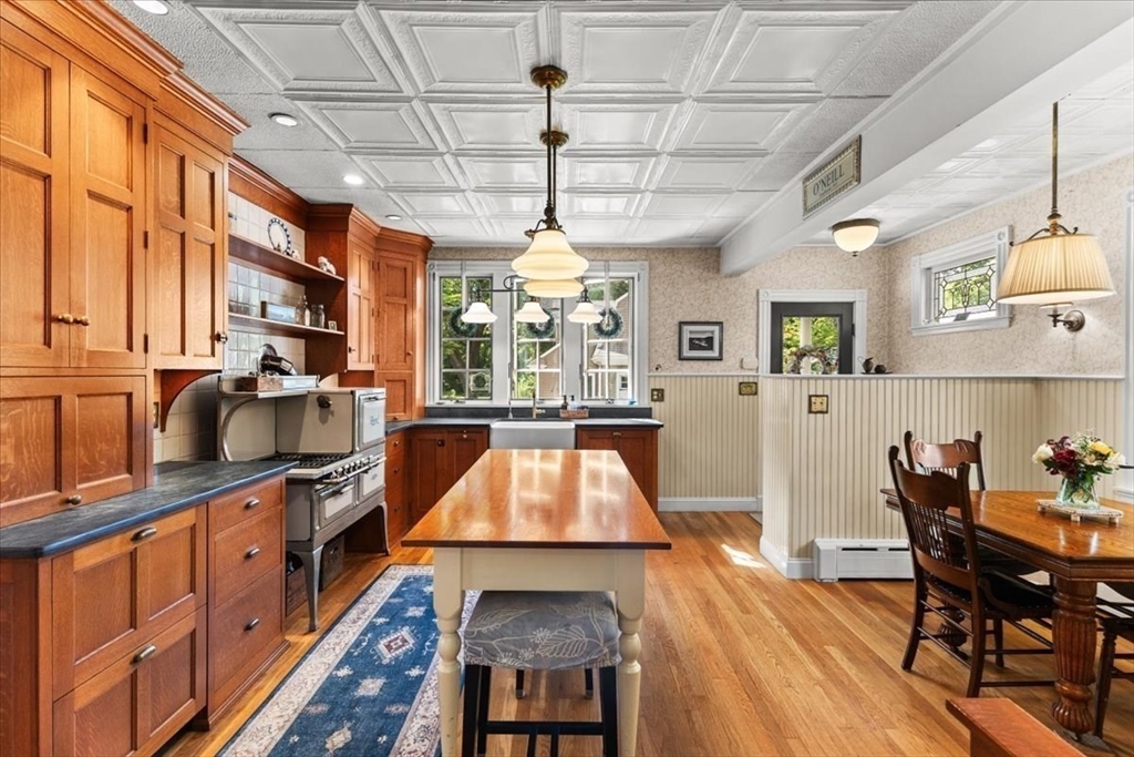 155 Mt Vernon Street Dedham, MA 02026 - Photo 28 of 50 a kitchen with stainless steel appliances granite countertop a kitchen island a stove a sink a dining table and chairs with wooden floor