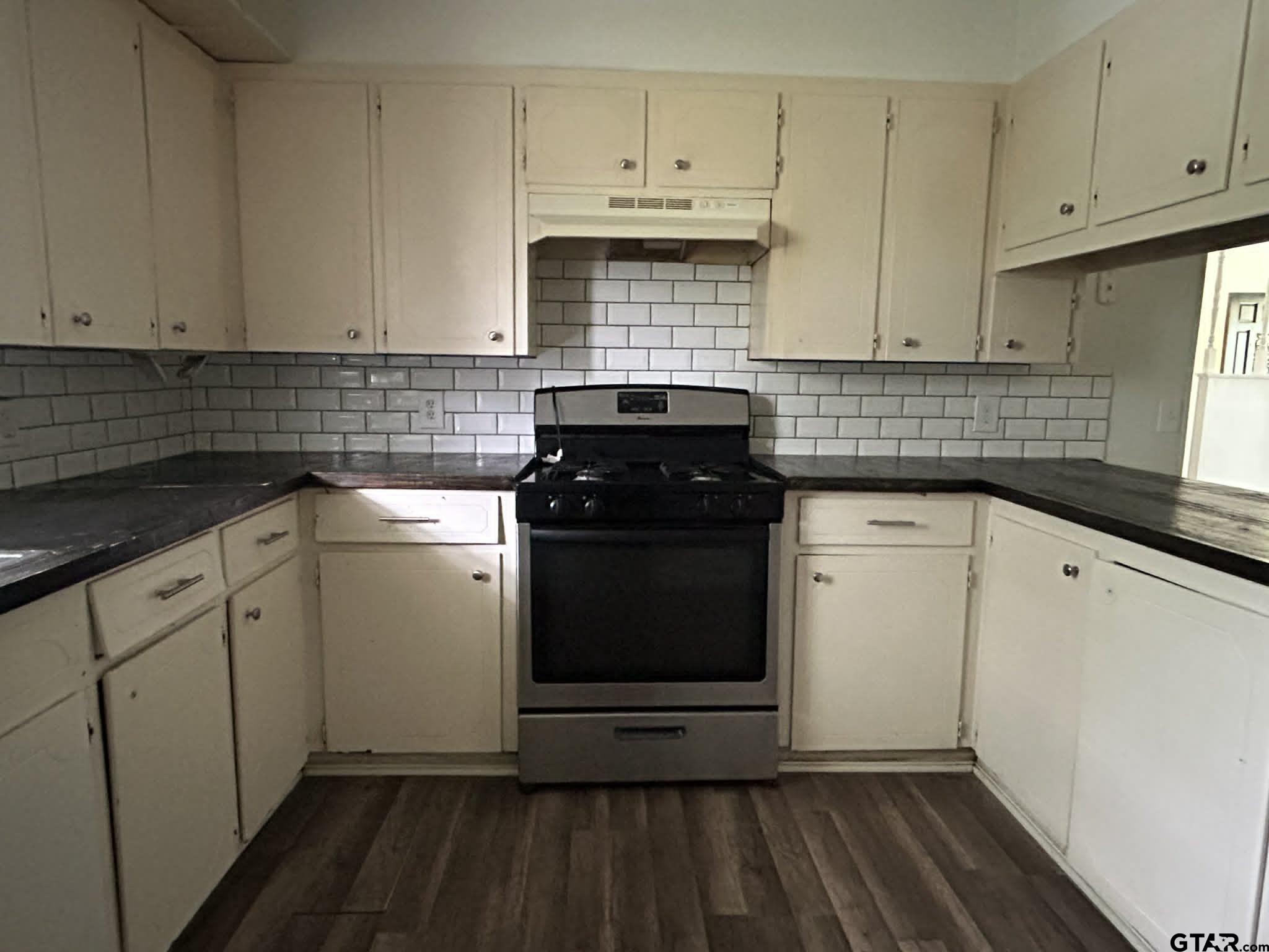 15987 State Highway 155 Tyler, TX 75703 - Photo 6 of 11 a kitchen with granite countertop white cabinets and white appliances