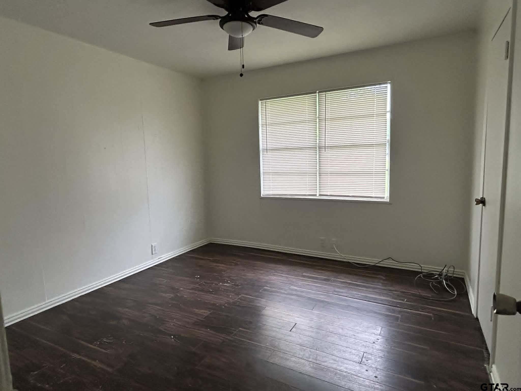 15987 State Highway 155 Tyler, TX 75703 - Photo 10 of 11 an empty room with wooden floor ceiling fan and windows
