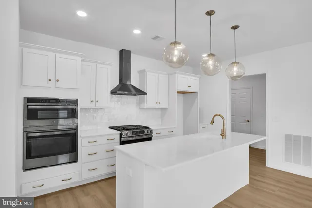 a kitchen with stainless steel appliances a stove a sink and a view of kitchen