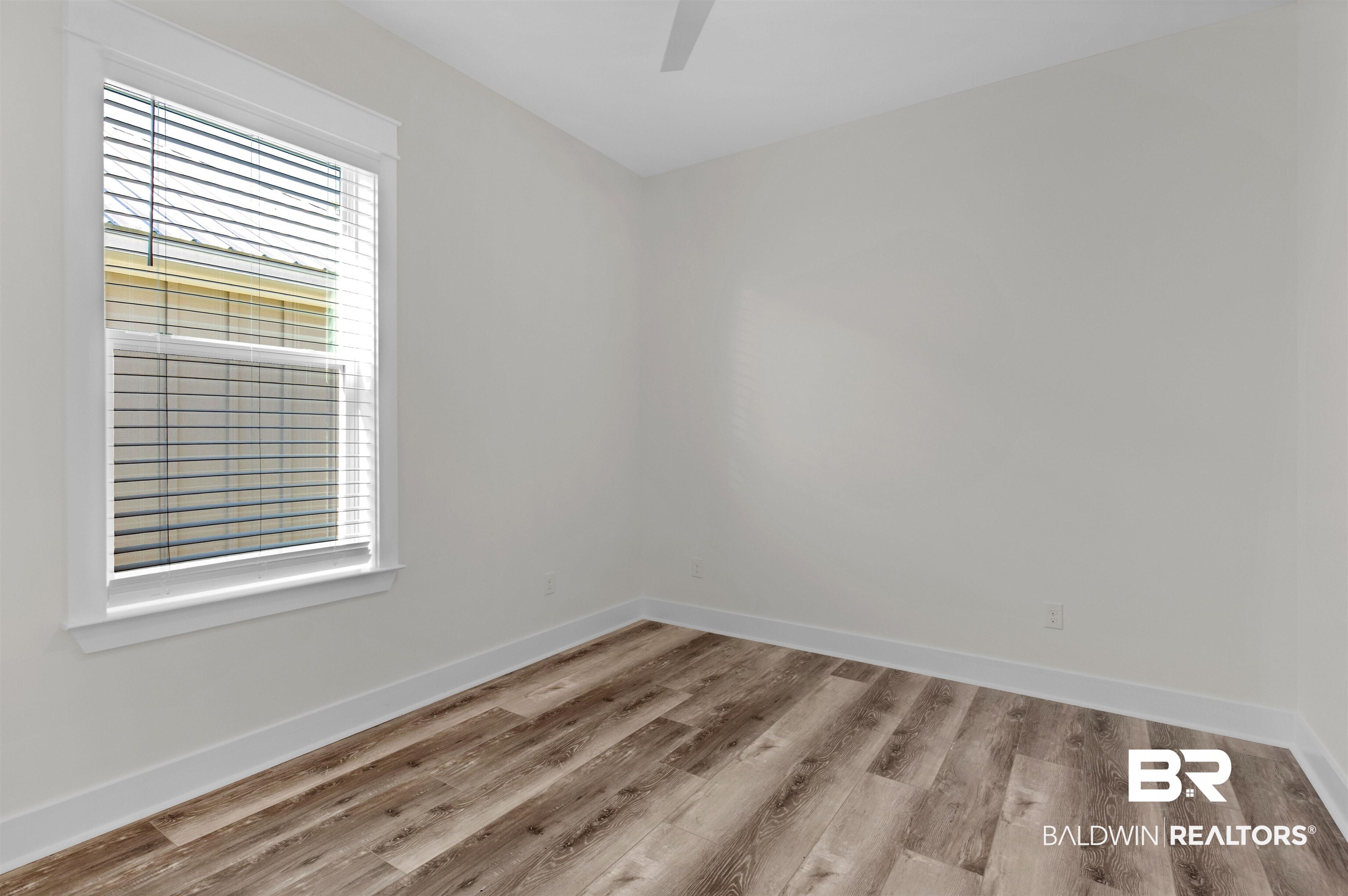 8069 Carmel Circle Foley, AL 36535 - Photo 13 of 23 Empty room with baseboards, wood finished floors, and ceiling fan