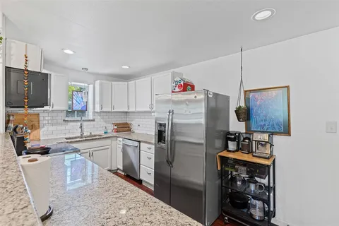 a kitchen with refrigerator and cabinets