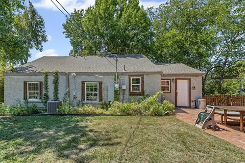 a view of a house with backyard garden and a tree