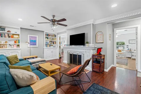 a living room with furniture a flat screen tv and kitchen view