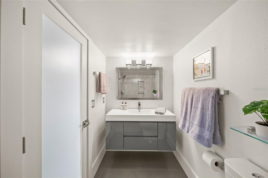 420 Beach Road, Unit 606 Sarasota, FL 34242 - Photo 30 of 83 a bathroom with a sink a mirror and a shower