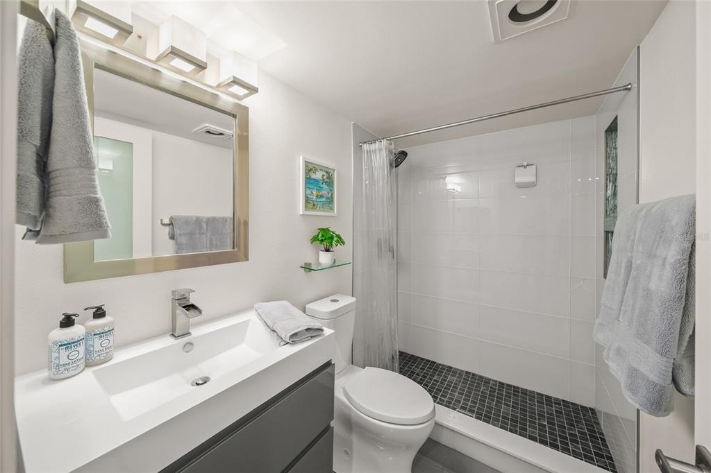 420 Beach Road, Unit 606 Sarasota, FL 34242 - Photo 37 of 83 a bathroom with a toilet a sink a mirror a vanity and shower