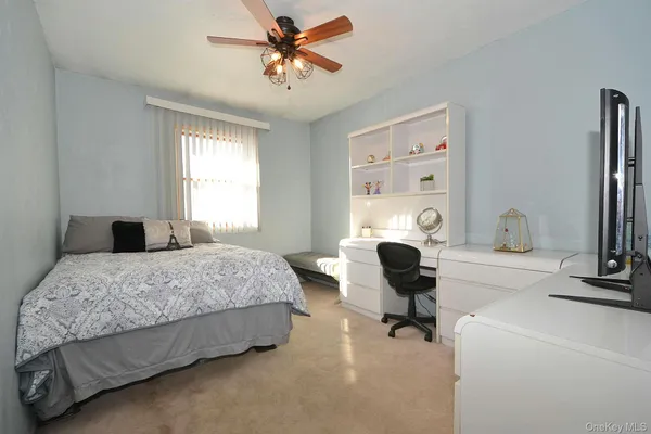 an empty room with a window and a fan
