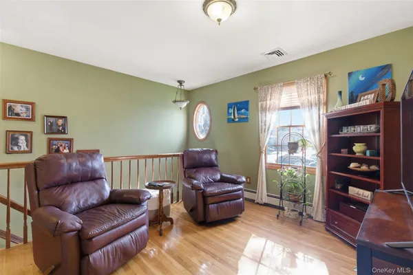 a living room with furniture a bookshelf and a window