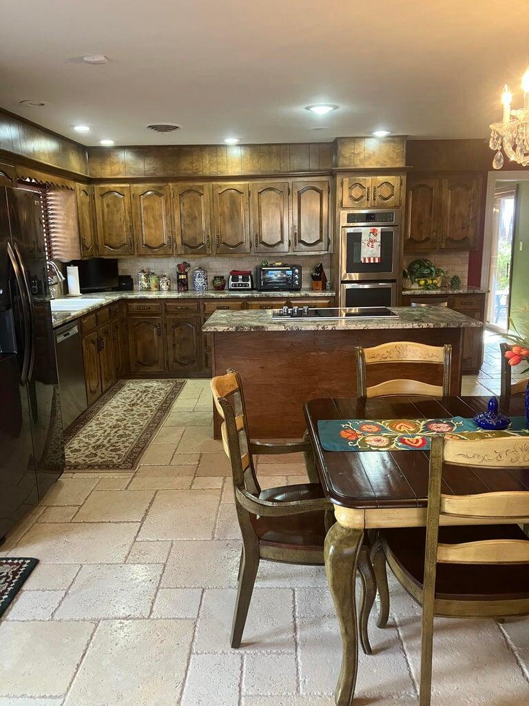 7303 Olton Road Plainview, TX 79072 - Photo 15 of 56 a kitchen with stainless steel appliances kitchen island granite countertop a sink and cabinets