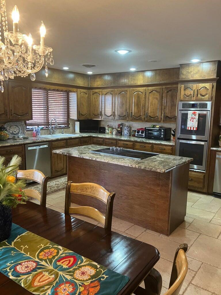 7303 Olton Road Plainview, TX 79072 - Photo 18 of 56 a living room with stainless steel appliances furniture a rug and a kitchen view