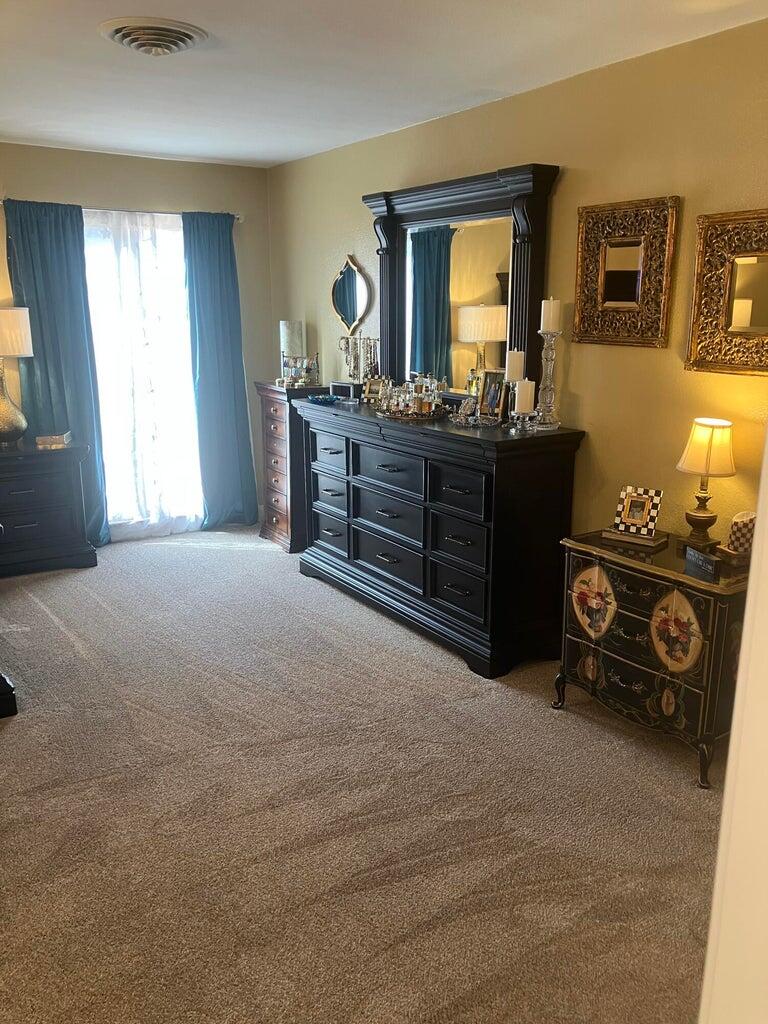 7303 Olton Road Plainview, TX 79072 - Photo 33 of 56 a room with a bed and a mirror on dresser