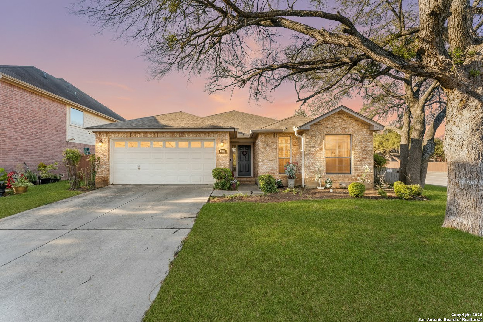 a front view of a house with a garden and yard
