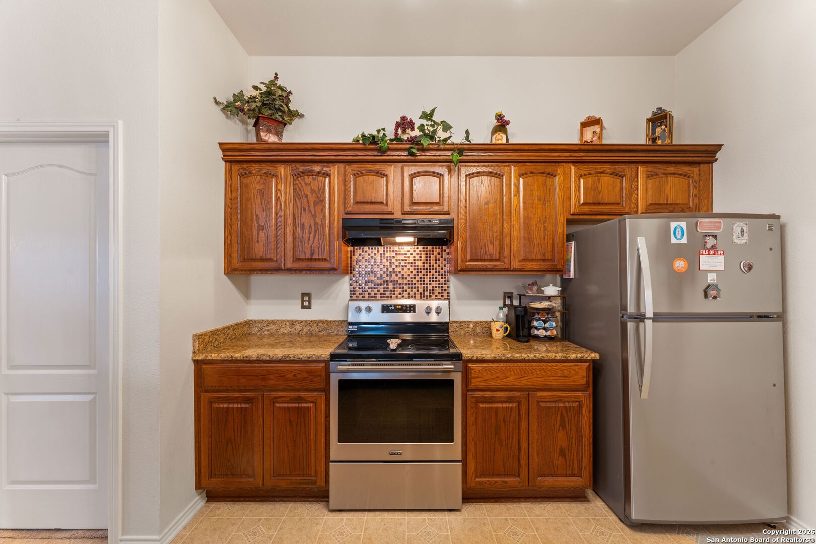 13127 Forum Universal City, TX 78148 - Photo 12 of 33 a kitchen with cabinets a refrigerator and a stove