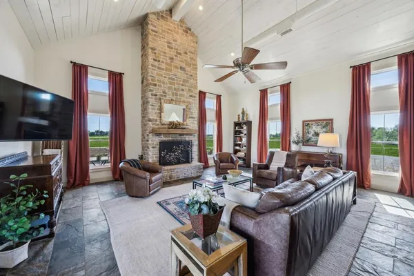 a living room with furniture a flat screen tv and a large window