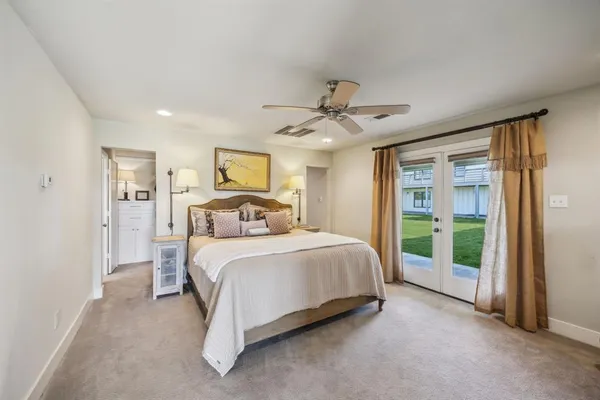 a spacious bedroom with a large bed and a chandelier