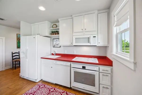 a kitchen with white cabinets and white appliances