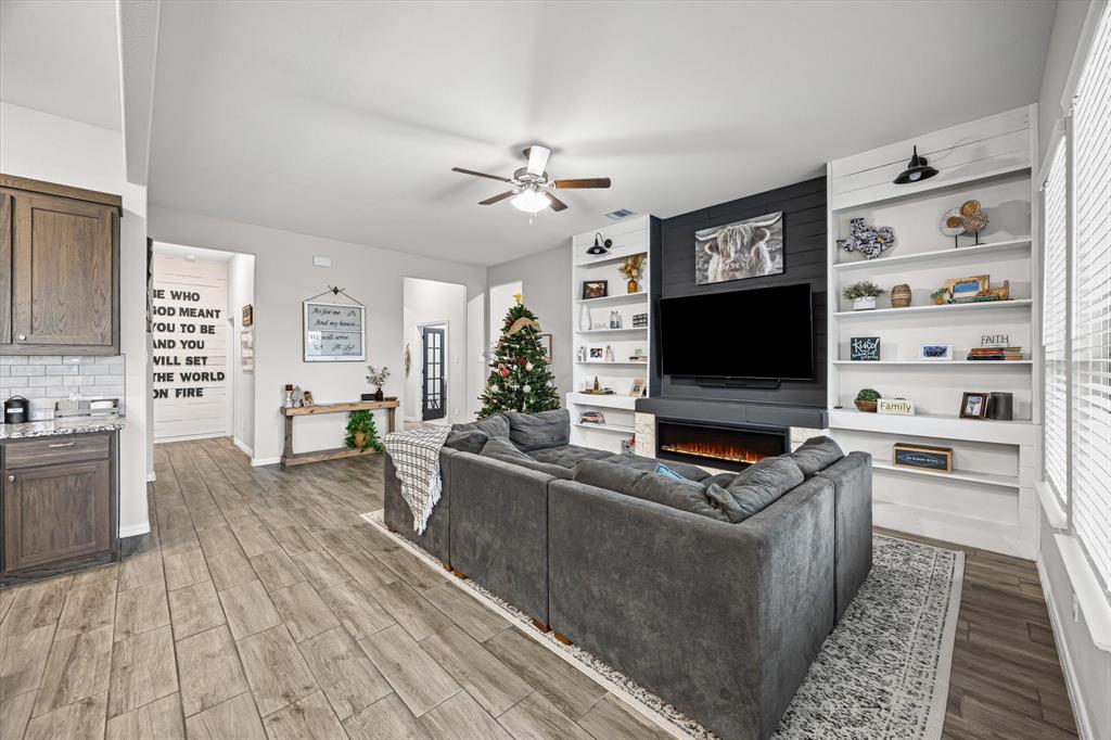 5405 Ranger Drive Midlothian, TX 76065 - Photo 11 of 29 Living area featuring wood tiled floors, a fireplace, and ceiling fan