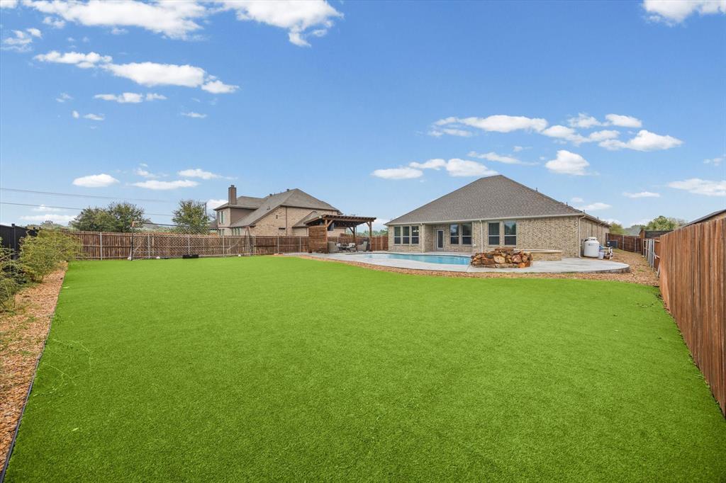 5405 Ranger Drive Midlothian, TX 76065 - Photo 3 of 29 Fenced backyard featuring a patio and artificial turf for easy backyard maintenance