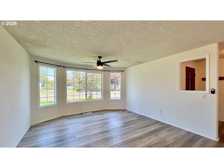 19504 Southwest Stacey Street Beaverton, OR 97003 - Photo 3 of 16 a room with a window and wooden floor