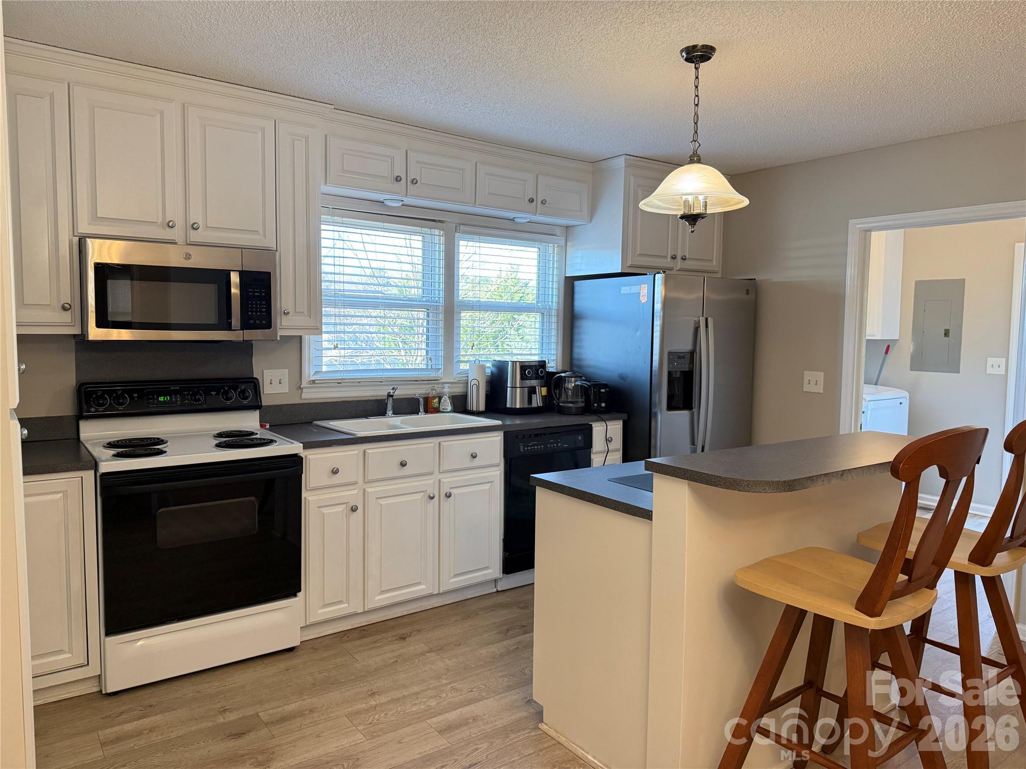 240 Nixon Road Belmont, NC 28012 - Photo 3 of 13 a kitchen with stainless steel appliances a stove a sink island a stove cabinets and a dining table
