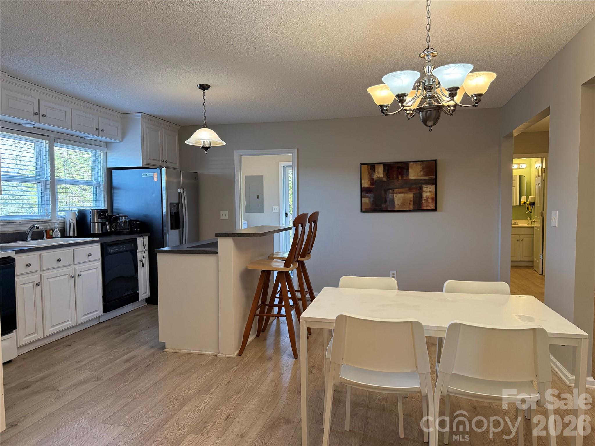 240 Nixon Road Belmont, NC 28012 - Photo 4 of 13 a dining room with wooden floor a chandelier a wooden table and chairs