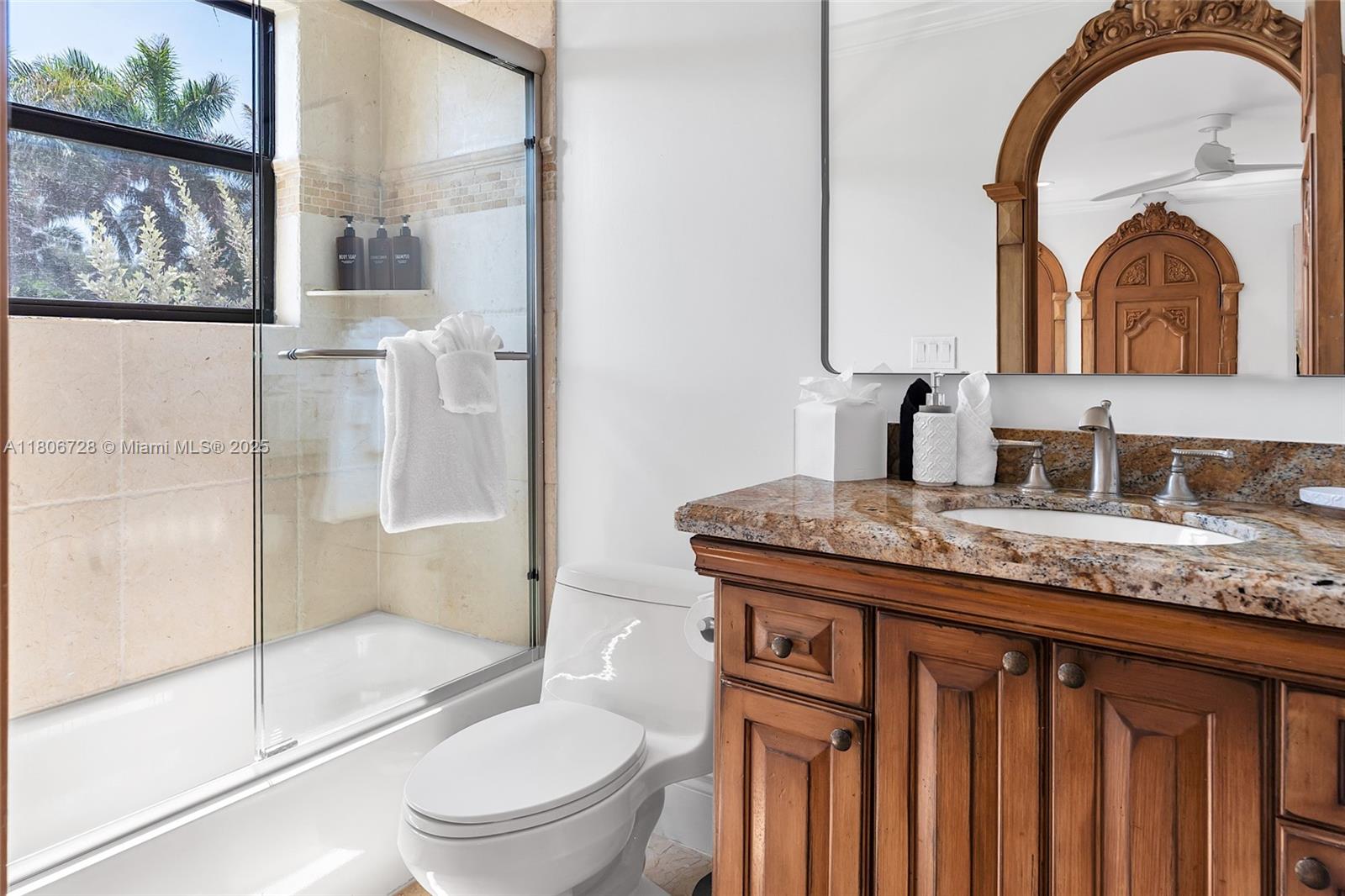 1011 Rhodes Villa Avenue Delray Beach, FL 33483 - Photo 59 of 90 a bathroom with a granite countertop sink a toilet and a mirror