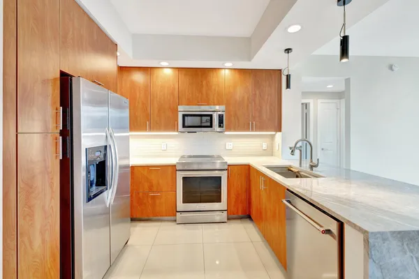 a kitchen with stainless steel appliances granite countertop a refrigerator and a stove top oven