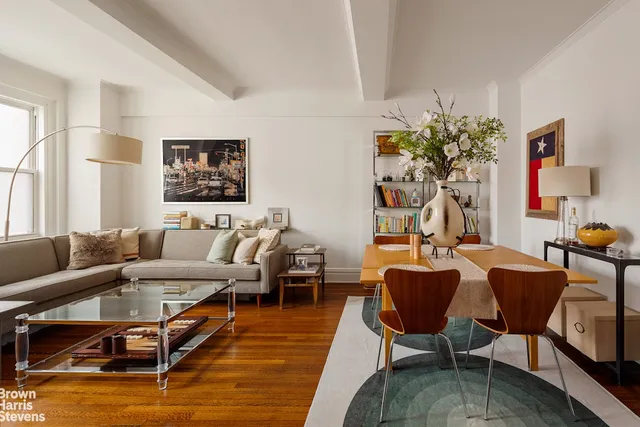 a living room with furniture wooden floor and a dining table