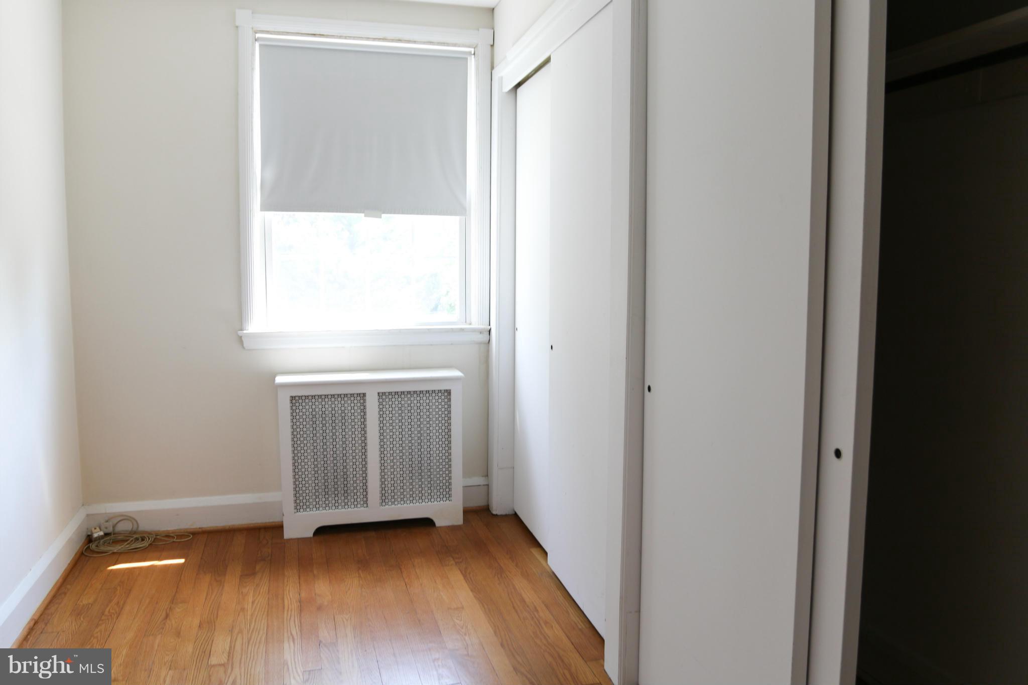 309 Westowne Road Baltimore, MD 21229 - Photo 13 of 20 a view of an empty room with wooden floor and a window