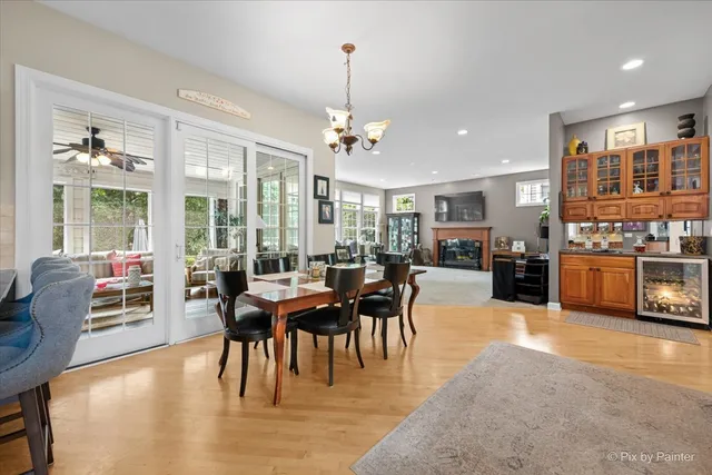 a view of a dining room and livingroom with furniture wooden floor a chandelier