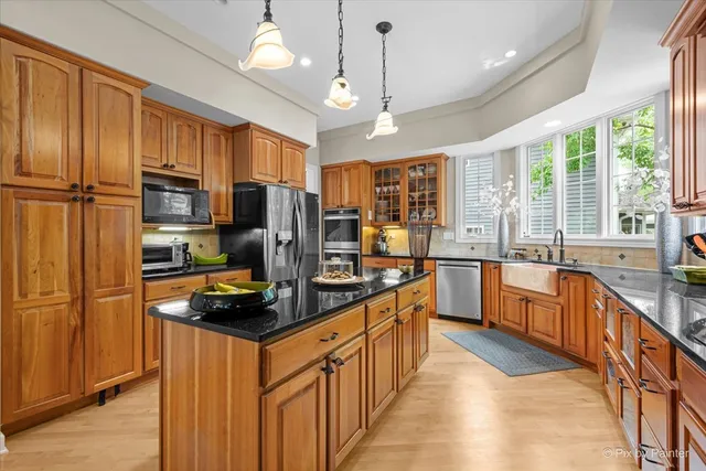 a kitchen with stainless steel appliances granite countertop a refrigerator a stove and a sink