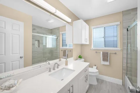 a bathroom with a sink a toilet and shower