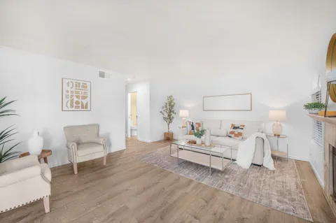 a living room with furniture and a wooden floor