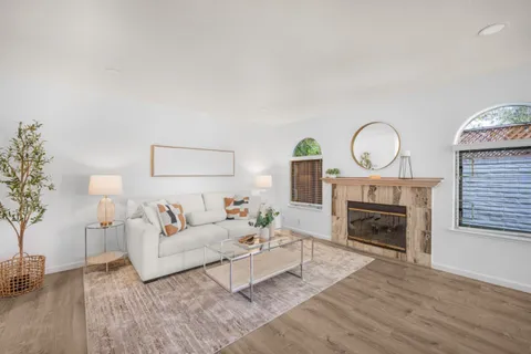 a living room with furniture a fireplace and a potted plant