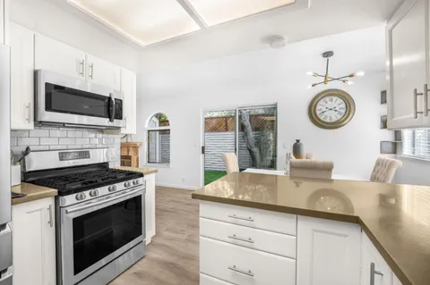 a kitchen with granite countertop a stove and a microwave