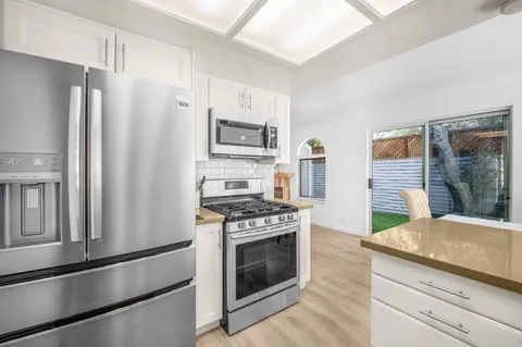 a kitchen with granite countertop a refrigerator stove and microwave