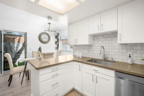 a kitchen with a sink and a clock on the wall
