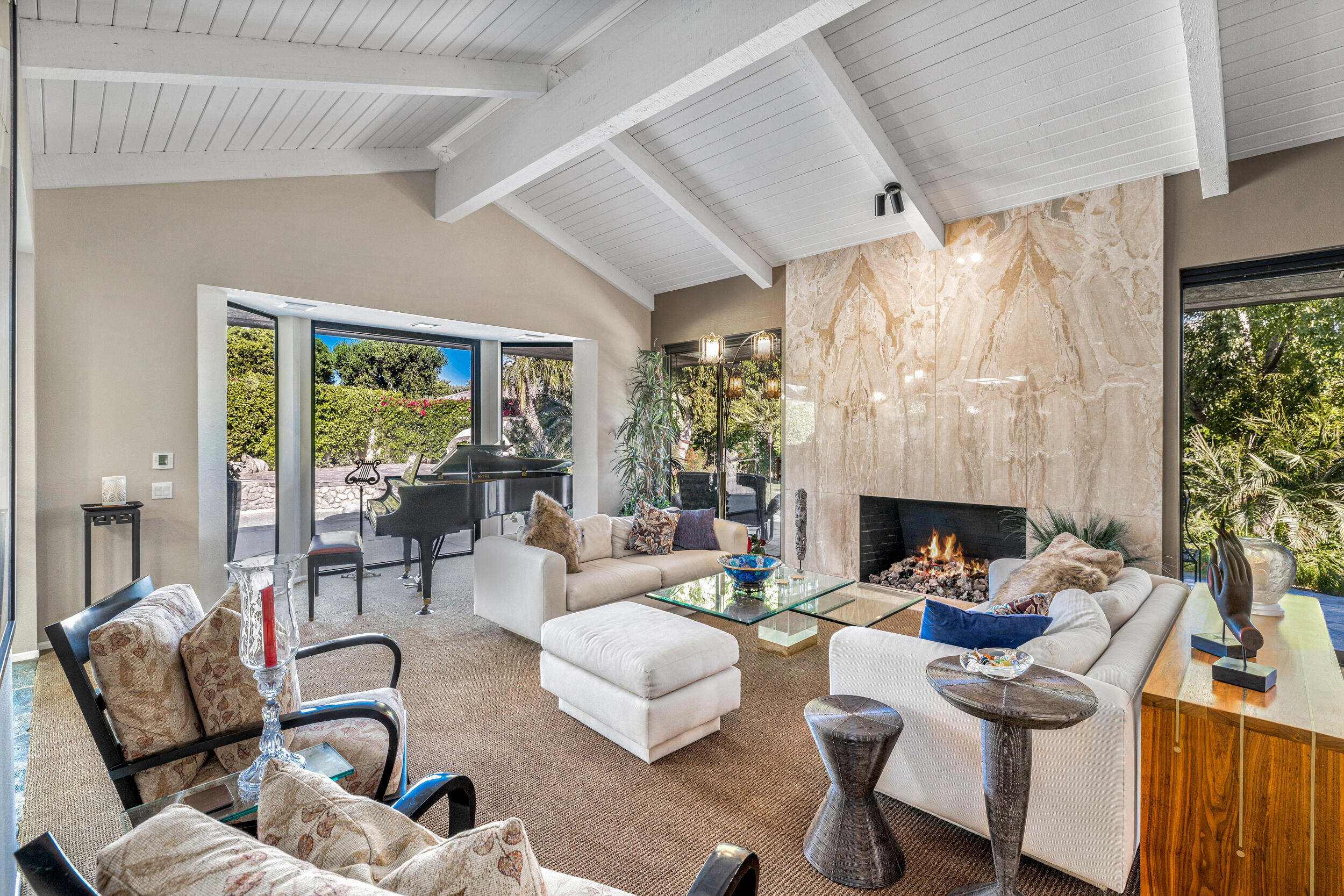 15 Johnar Boulevard Rancho Mirage, CA 92270 - Photo 17 of 68 a living room with furniture a fireplace and a floor to ceiling window